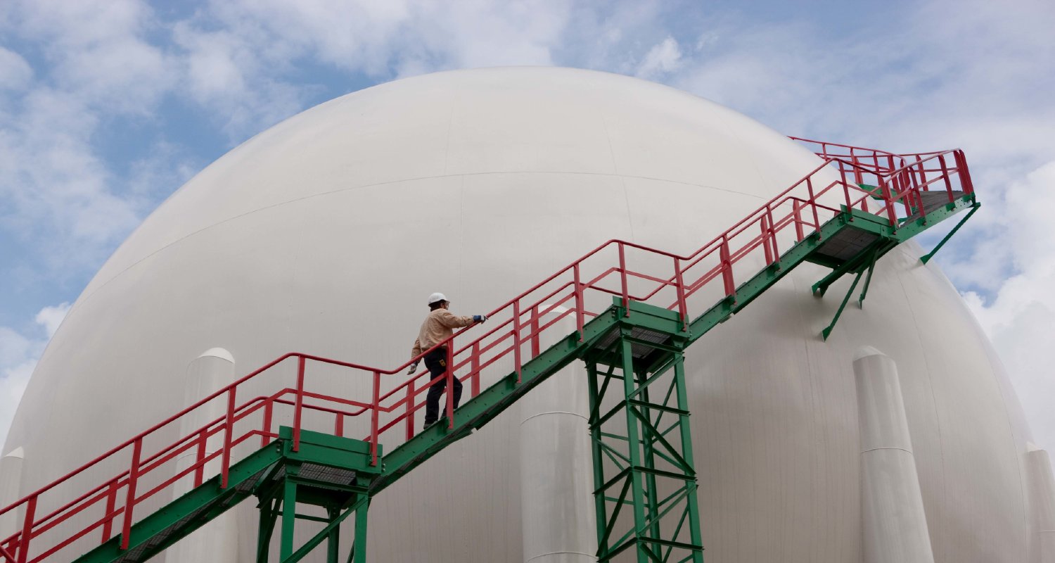 Operario con casco subindo escaleiras na refinar&iacute;a